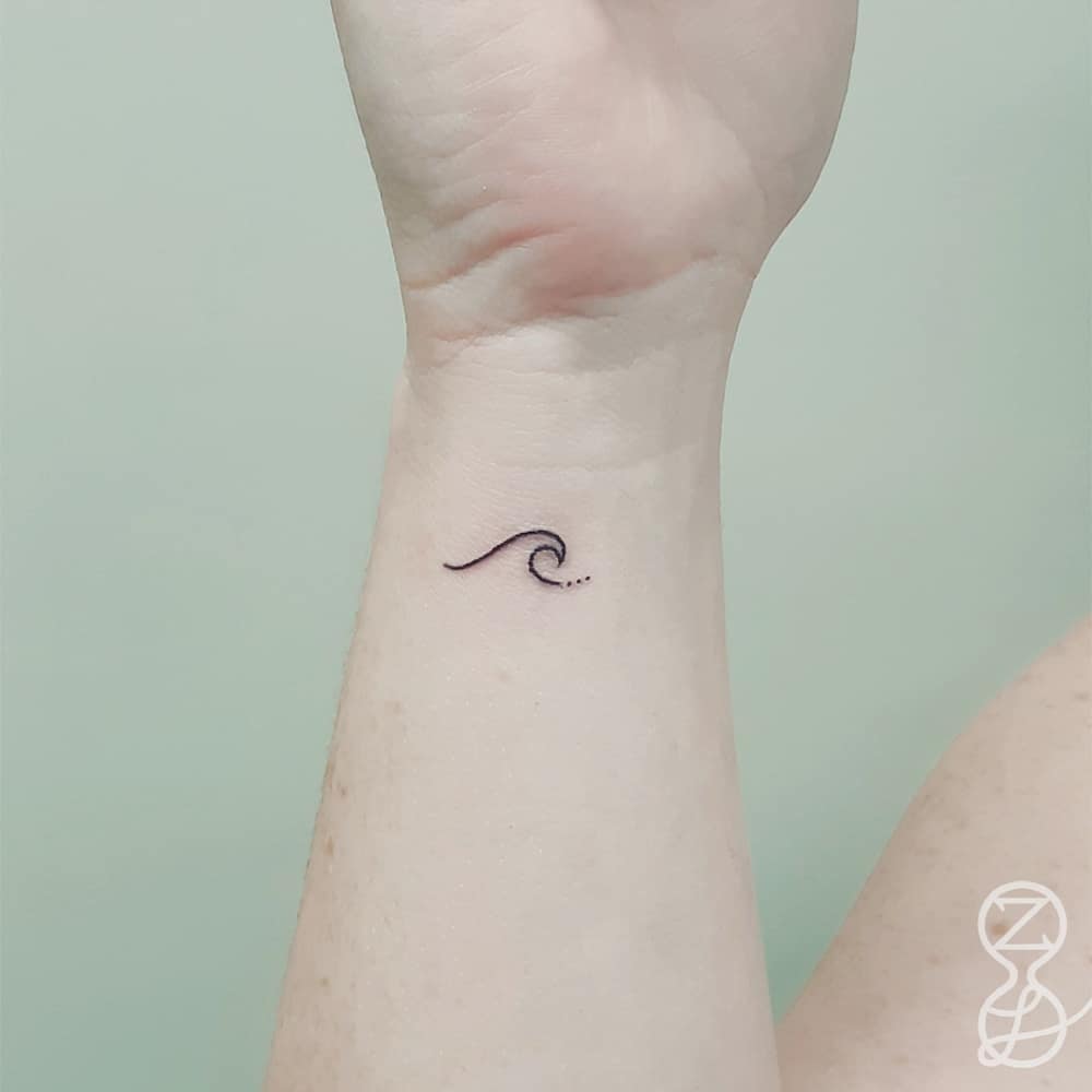 delicate wrist tattoo of a little wave