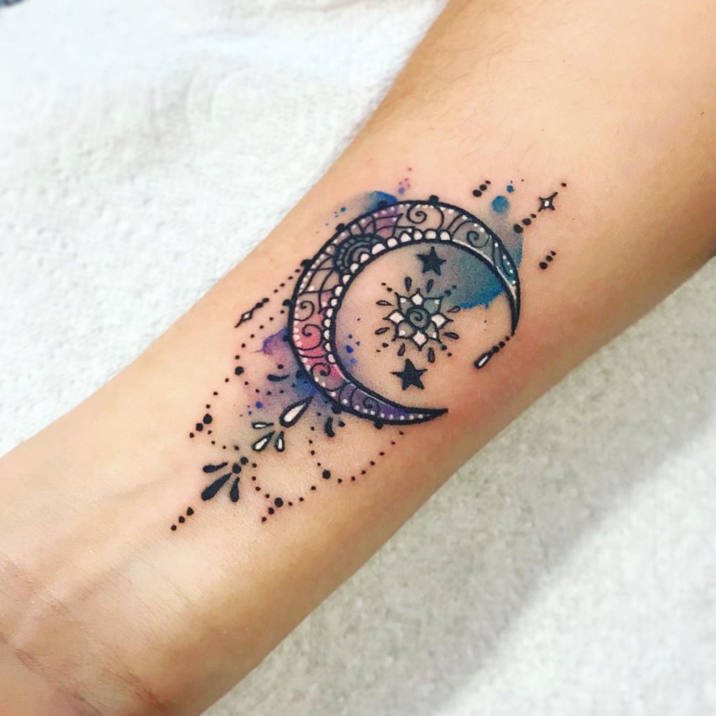 watercolor style moon tattoo on wrist with onaments