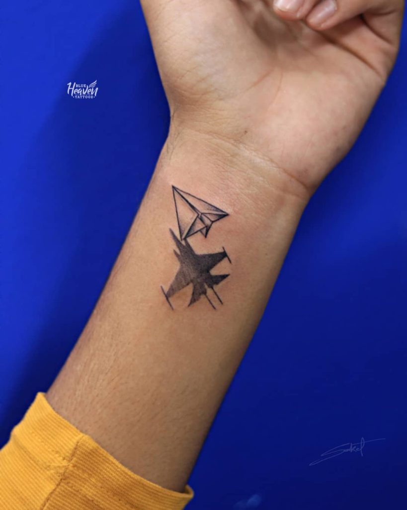 paper plane tattoo on wrist