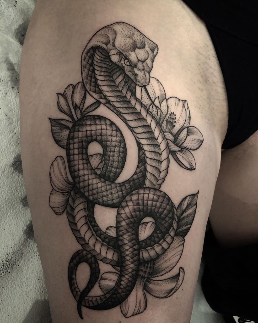 Fine line snake tattoo on the thigh