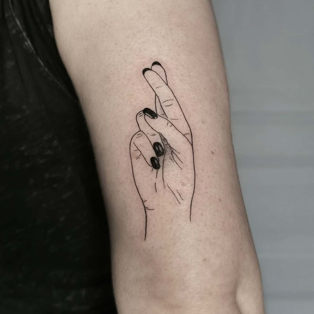 Crossed fingers tattoo on the ankle