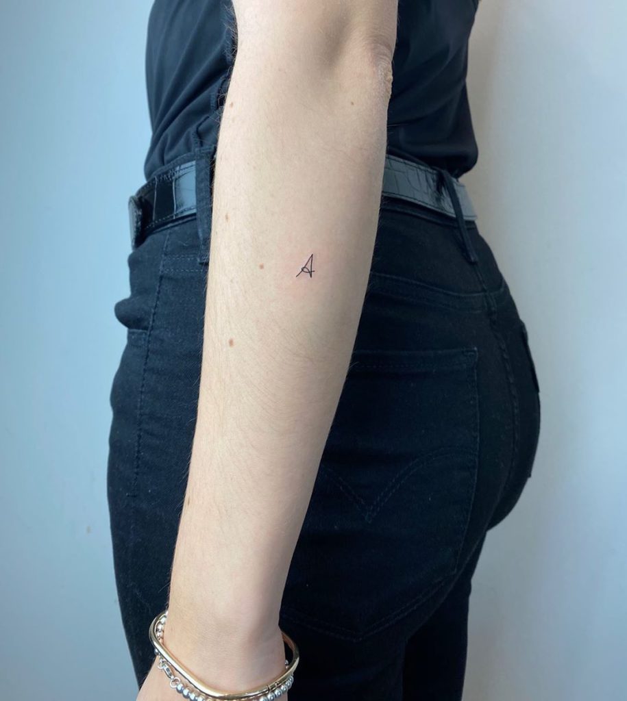 Letter tattoo on Forearm (back) by Maitê De Castro Fonseca