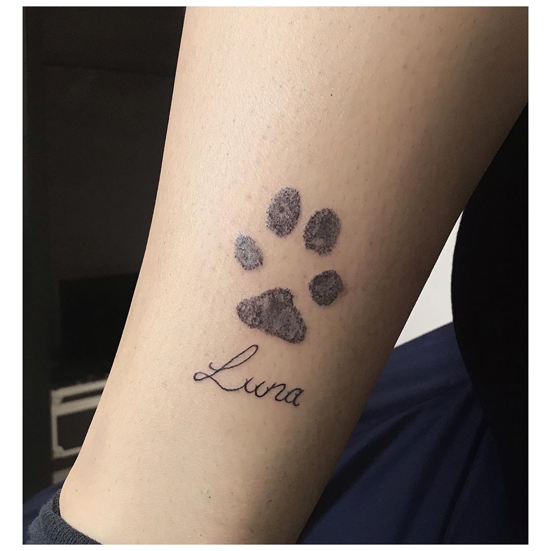 Minimalist dog paw tattoo on the wrist