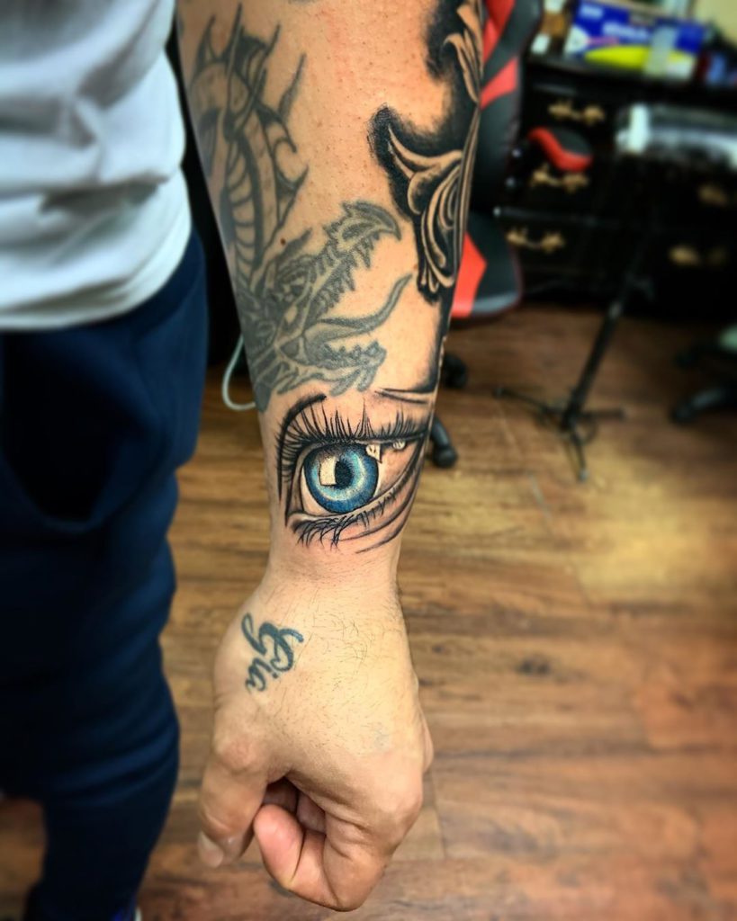 Eye tattoo on Wrist (top) - Color style by Izzy Garcia