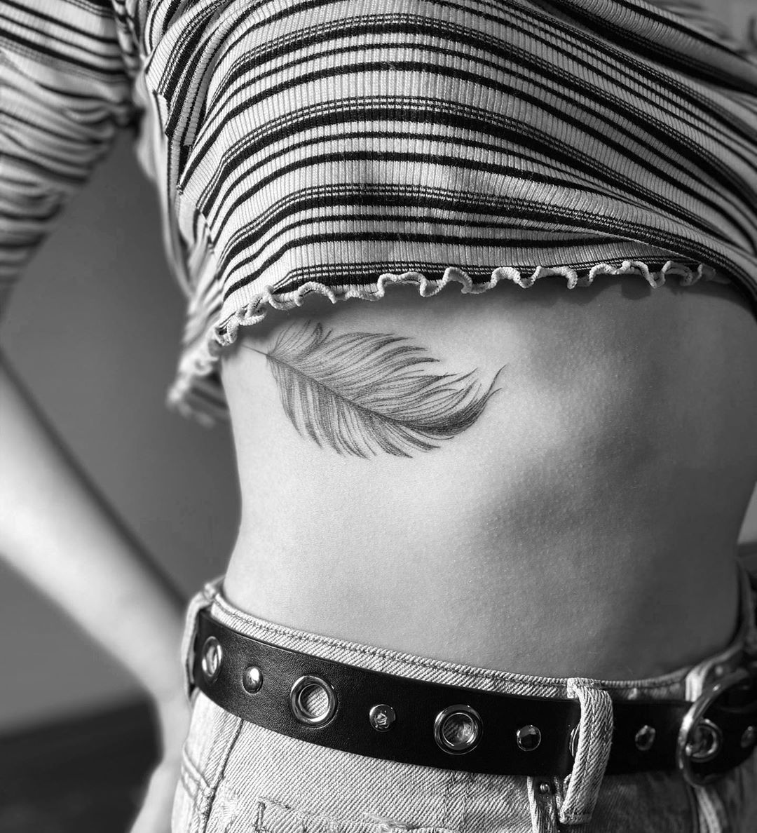 Feather tattoo on the right side ribcage