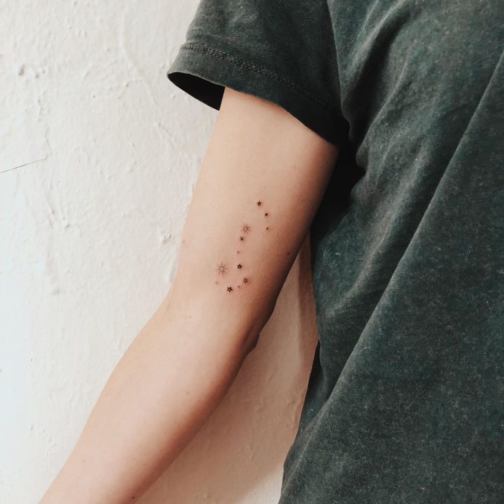 Minimalist Taurus constellation tattoo on the bicep